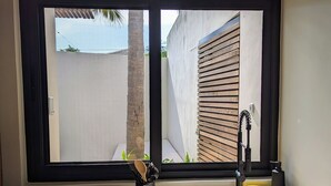 A kitchen with a large window, a sink, and a dishwasher. - Punta Mágica (Puerto Escondido)