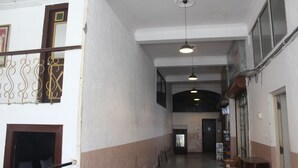 A corridor with a staircase on the left, a door at the end, and a hanging light fixture. - Shree Chitra Residency by Avadhesh Grou (Haridwar)
