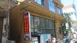 A hotel with a sign advertising a residency program, large windows, and a parked scooter outside. - Shree Chitra Residency by Avadhesh Grou (Haridwar)