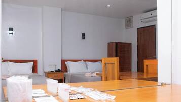 Habitación de hotel con dos camas, una mesa de madera con artículos de aseo y un espejo que refleja la habitación.
