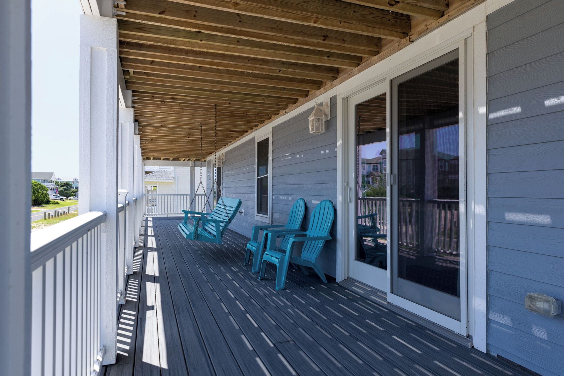 A covered porch with a wooden ceiling, a railing, and a view of the street.