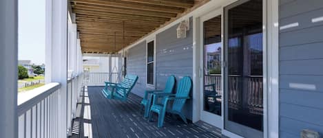 A covered porch with a wooden ceiling, a railing, and a view of the street.