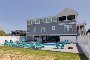 A two-story house with a covered outdoor deck and a swimming pool. - A Golden Opportunity: Semi-Oceanfront w/Heated Pool, Hot Tub and Across from Beach! (Corolla)