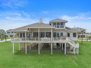 A two-story house with a covered deck and a staircase leading to the upper level.