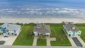 A coastal property with three houses, a beach, and the ocean. - Beachfront Beauty w/ Hot Tub ~ 10 Steps to Sand (Galveston)