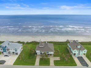 A coastal property with three houses, a beach, and the ocean. - Beachfront Beauty w/ Hot Tub ~ 10 Steps to Sand (Galveston)