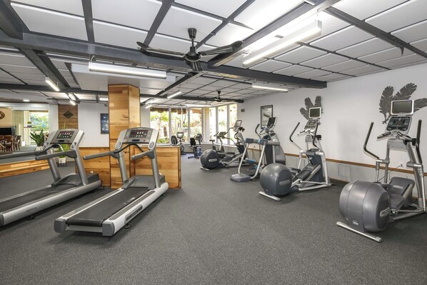 A gym with treadmills, elliptical machines, and stationary bikes.