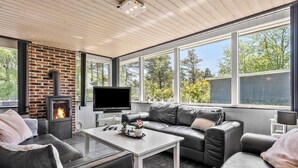 A cozy living room with a fireplace, leather sofa, and a flat-screen TV. - Stunning home in Tarm with kitchen (Tarm)