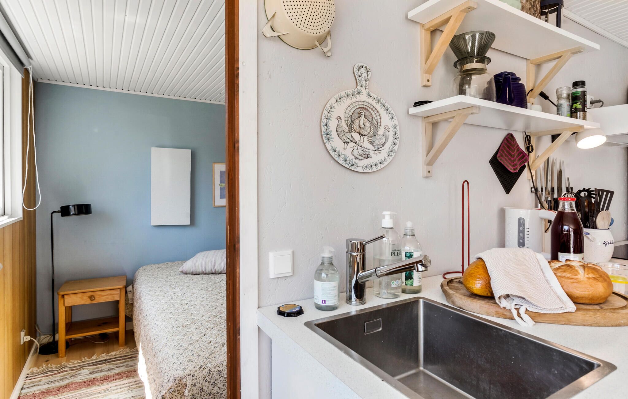 A compact kitchen with a sink, countertop, and various kitchen items.