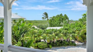 A lush garden with various tropical plants and a white structure with a curved roof. - Isla Lychee: Boutique Resort, FREE Boat Dockage Sep-Oct Only! (Islamorada)