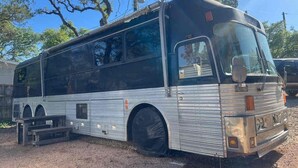 A stationary bus with a large front windshield, side windows, and a rearview mirror. - EL948 (Canyon Lake)