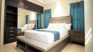 A modern bedroom with a large bed, a built-in bench, a wardrobe, and a nightstand. - D&D Divine Suite
Ocho Rios, St. Ann Parish (Ocho Rios)