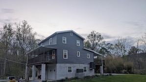 A two-story house with a balcony, a garage, and a well-maintained lawn.