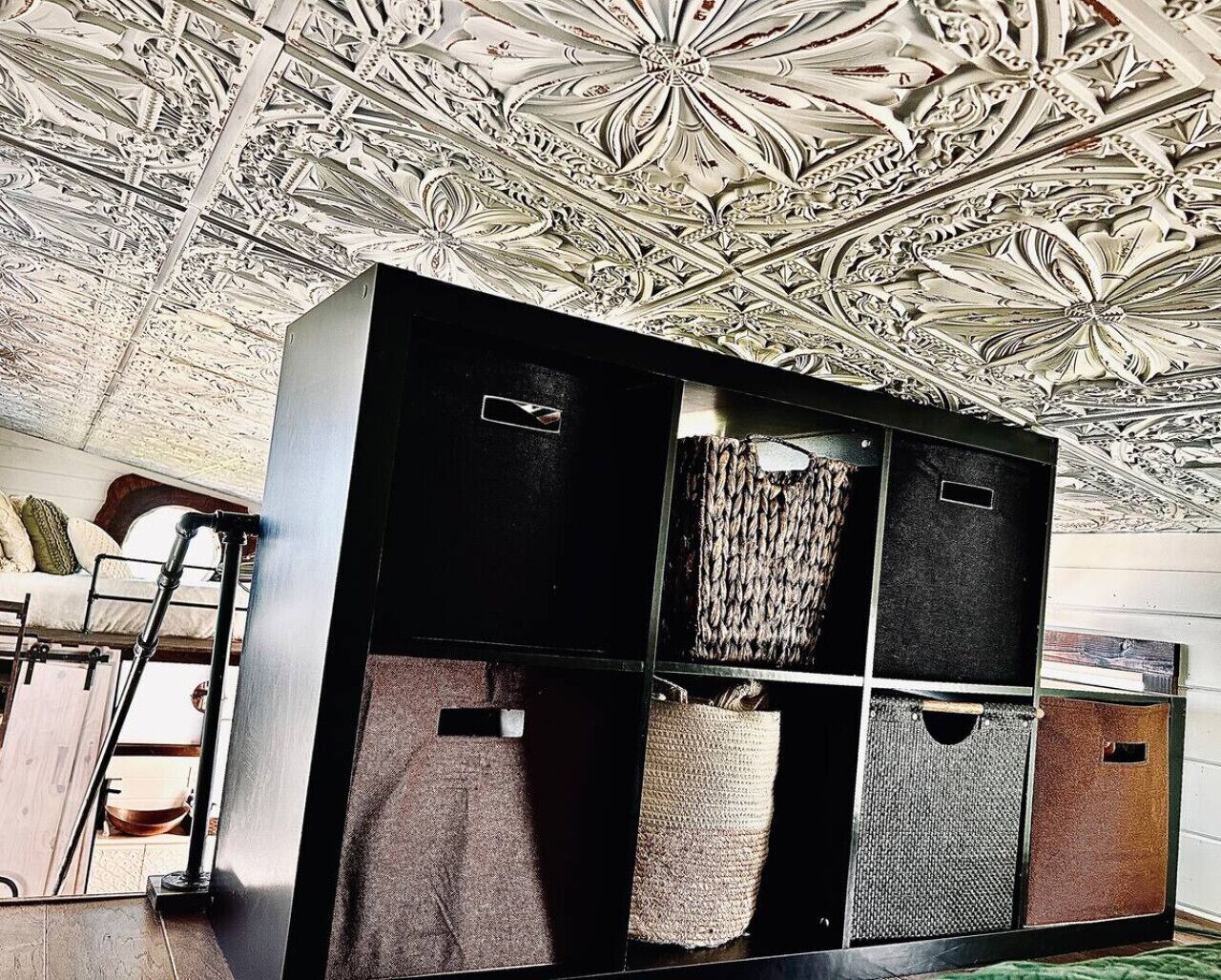 Een kamer met een stapelbed, een ladder en een grote kast met verschillende vakken.