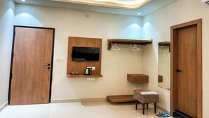 A modern bathroom with a wooden vanity, a mirror, a television, and a towel rack. - Hotel Neel Kamal (Jaipur)