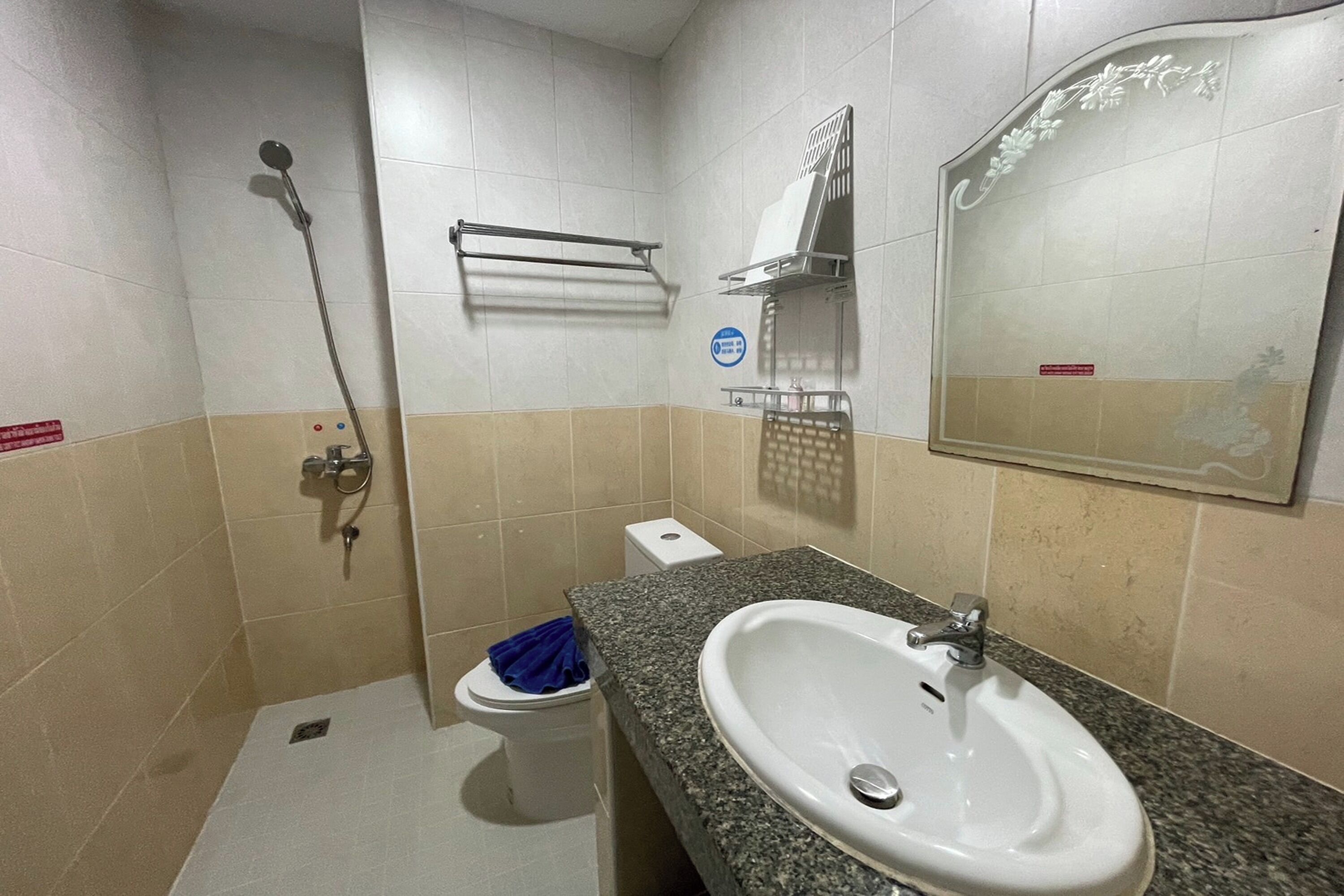 Une salle de bain équipée d’un lavabo, de toilettes, d’une douche et d’un porte-serviettes.