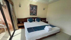 A neatly made bed with a blue and white bedspread, two pillows, and a folded towel. - One World One Home Patong 1 (Patong)