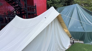Een tent met een wit en groen kleurenschema, opgesteld op kunstgras.