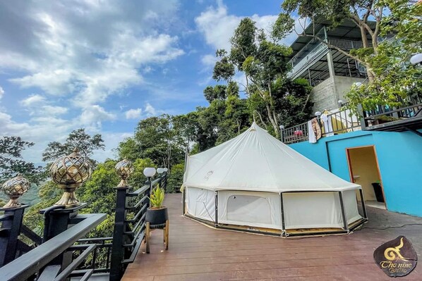 A white tent on a wooden deck with a view of a building and trees. - Kuan Khan Lao The Nine Bistro (Na Mom)