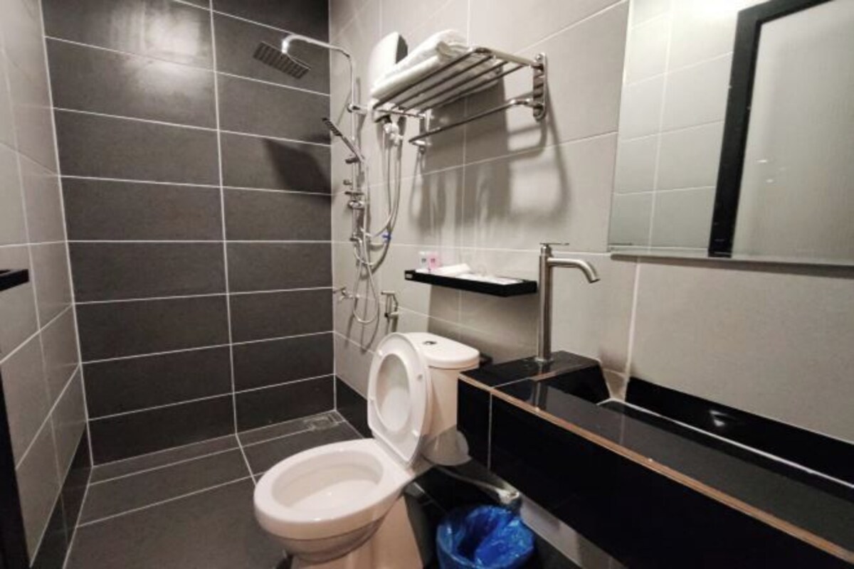 A modern bathroom with a toilet, bidet, and a towel rack.