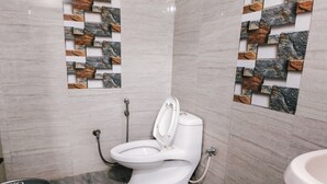 Un baño con inodoro blanco, ducha y lavamanos.