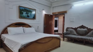 Un dormitorio con una cama de madera, un sofá y un cuadro en la pared.