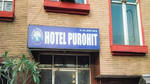 Señal de hotel con el nombre HOTEL PUROHIT y un número de teléfono.