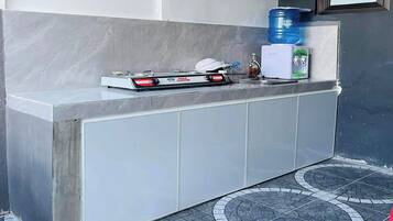 Angolo cottura con piano cottura a gas, dispenser d'acqua e lavello.