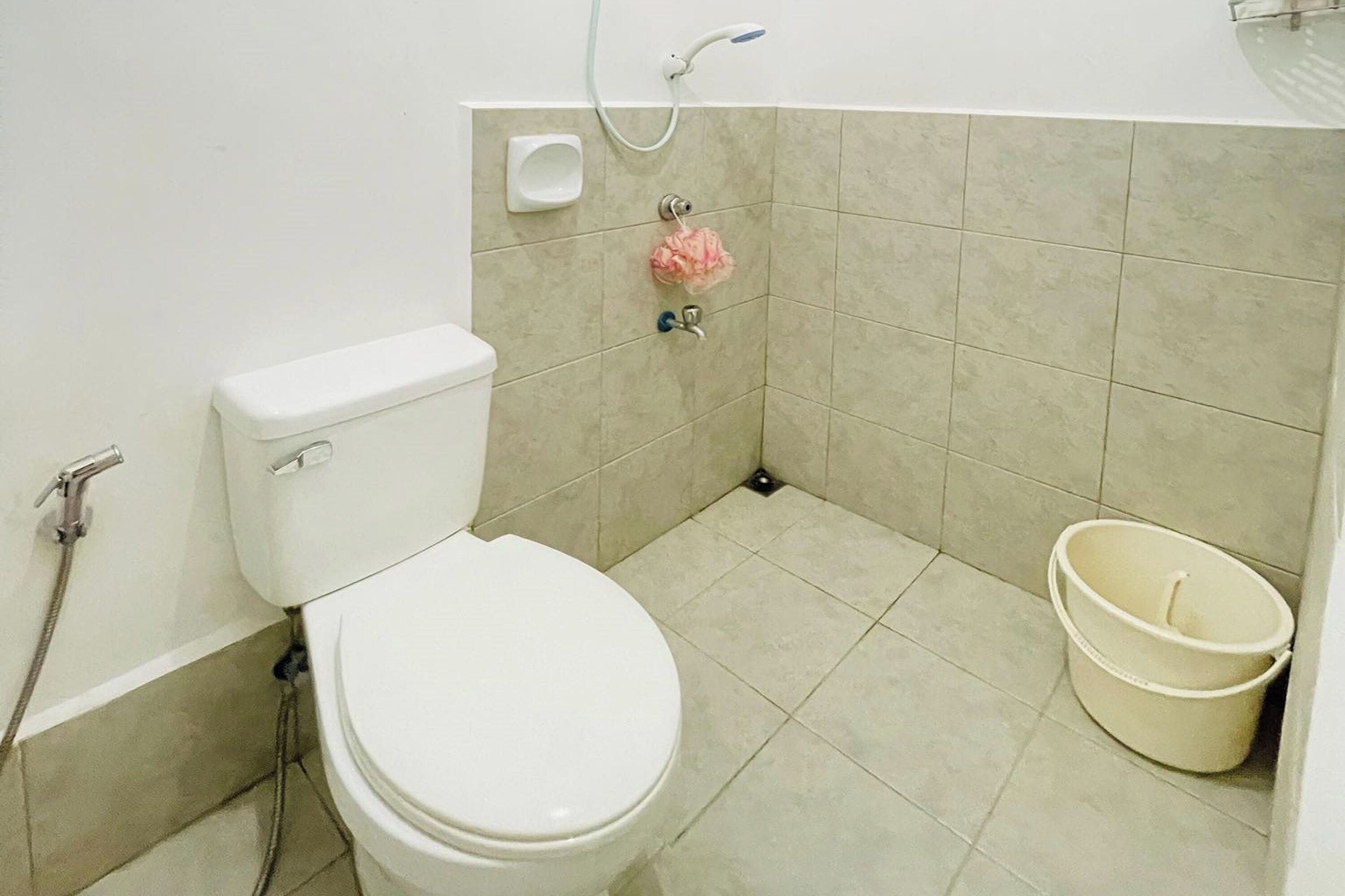 Et badeværelse med toilet, brusebad og en balje.
