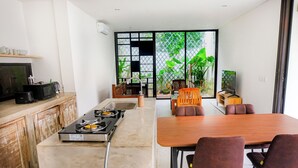 A modern kitchen with a gas stove, a sink, and a dining area with a table and chairs.