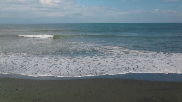 A beach with gentle waves and a clear sky. - Awel Seashore Inn Baler (Baler)