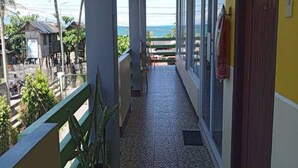 A balcony with a view of the ocean, a tiled floor, and a wooden railing. - Awel Seashore Inn Baler (Baler)