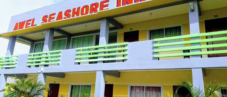 A two-story building with balconies and a sign reading "Avel Seashore Inn".