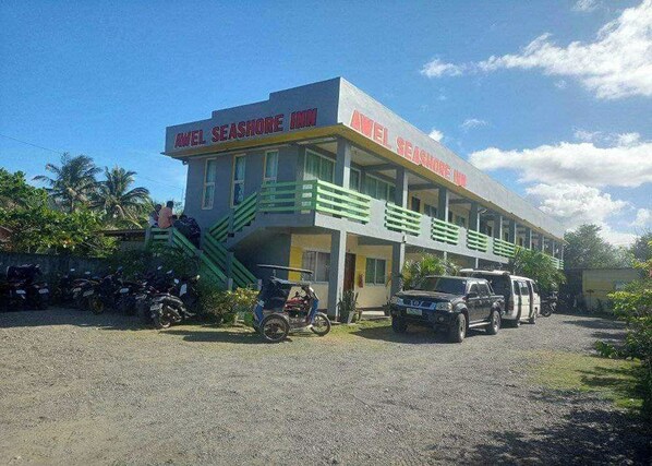 Un edificio de dos pisos con un letrero que dice "Ariel Seashore Inn".