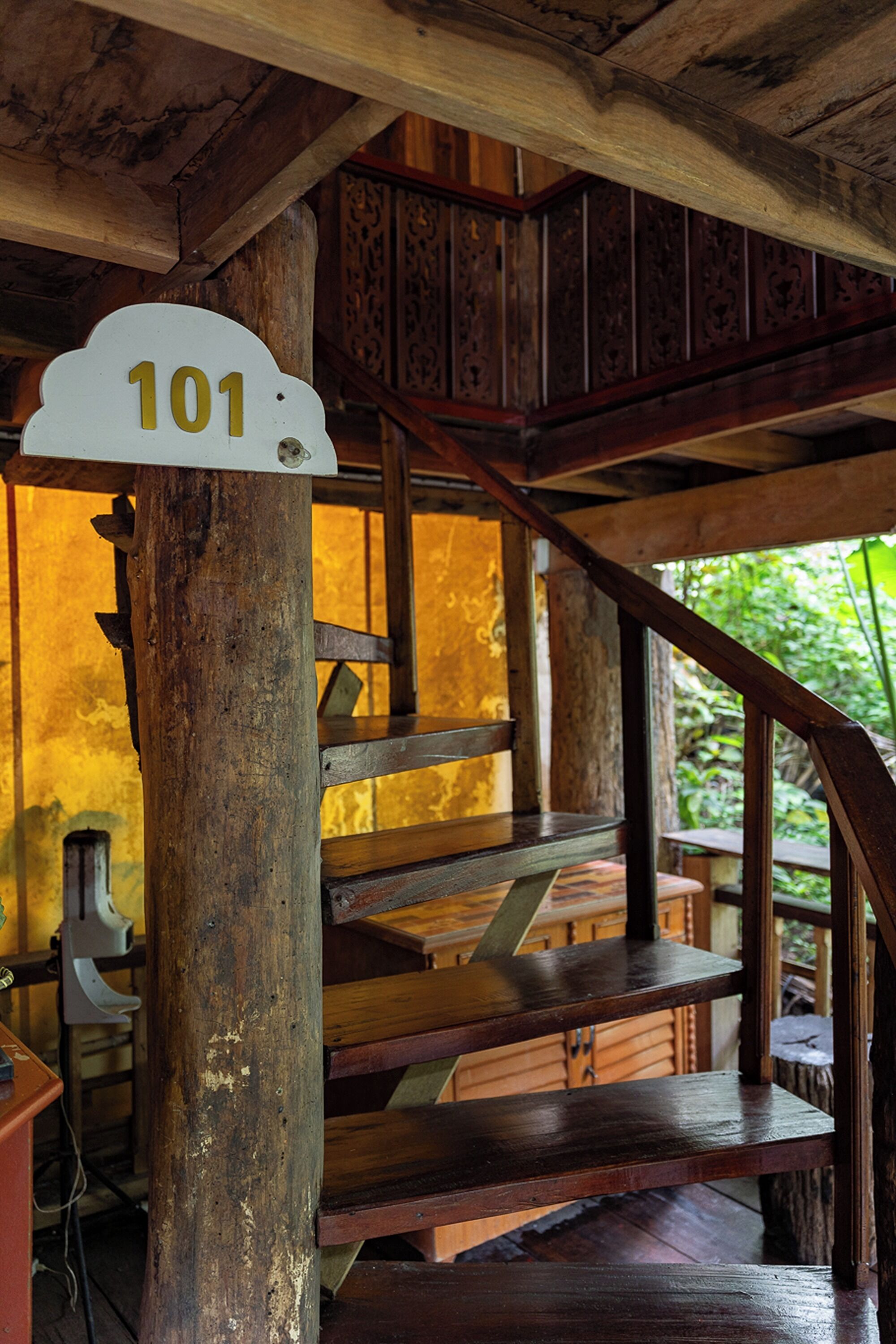 A wooden staircase with a sign indicating room number 101.
