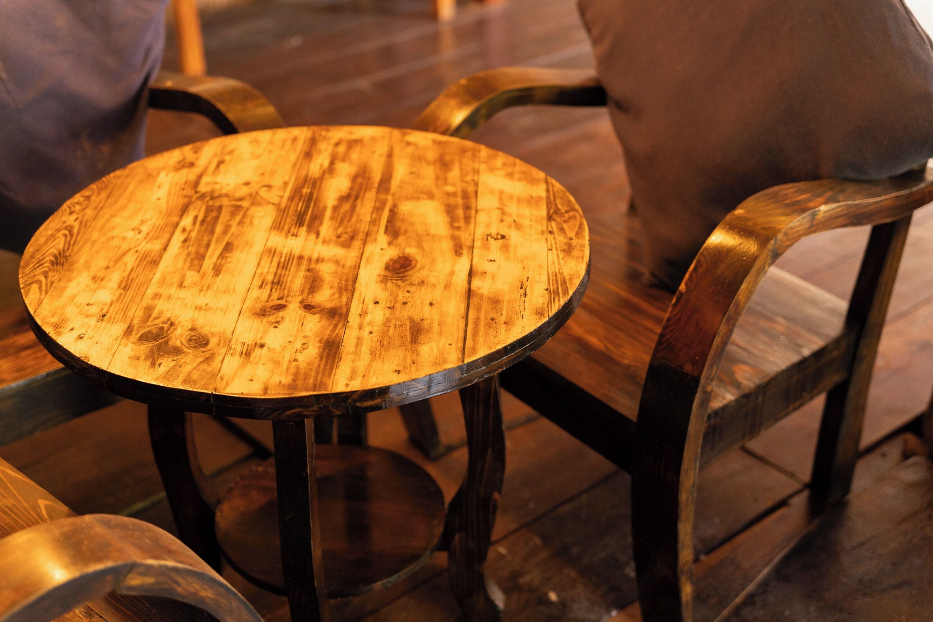 A round wooden table with metal legs, surrounded by metal chairs.
