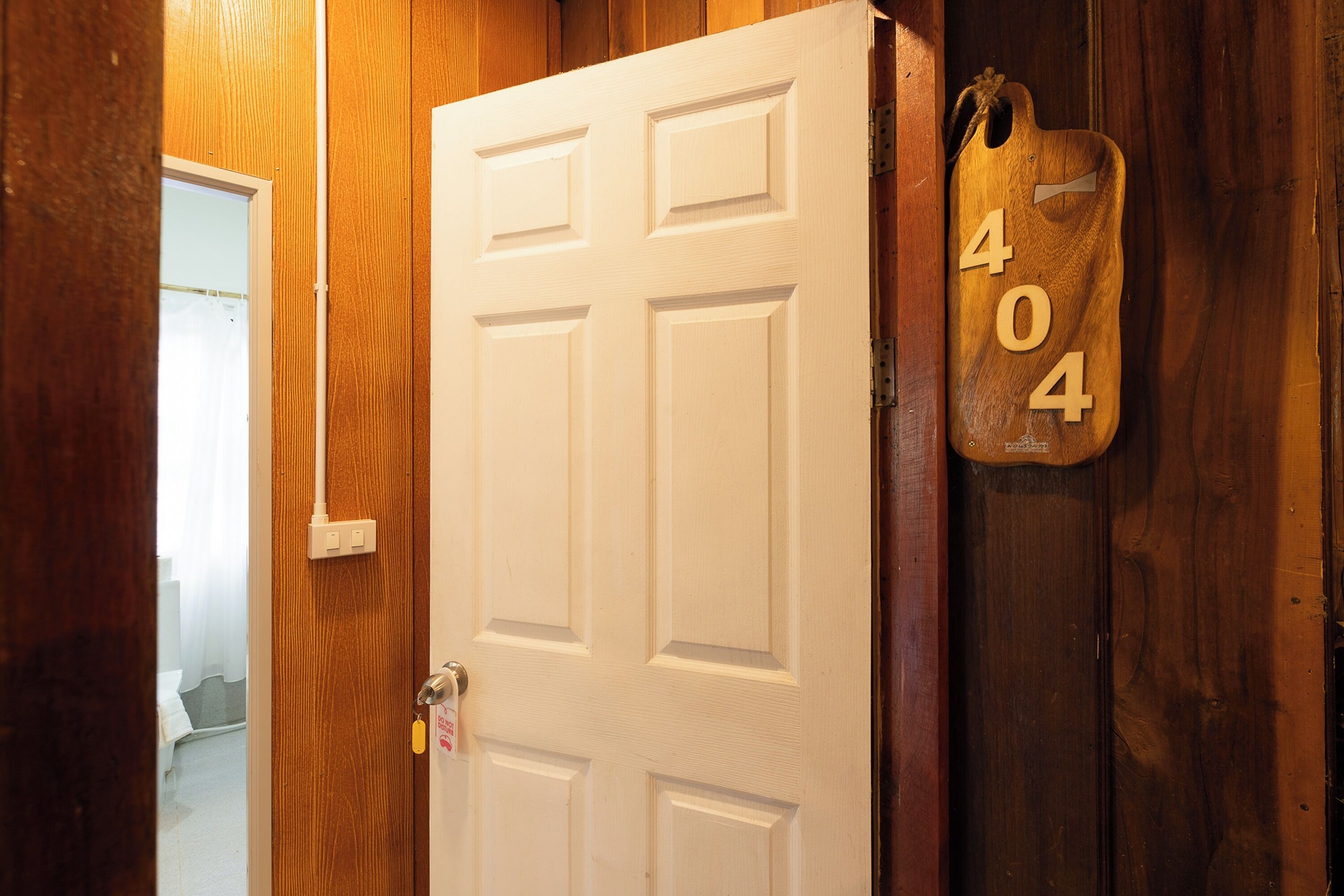 A wooden door with a white panel and a 404 sign on the right.