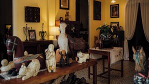 A room with a wooden table displaying various figurines and a lamp. - Bhirom At Baan Thongjaya (Hang Dong)