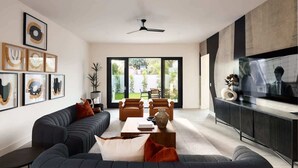 Ein modernes Wohnzimmer mit einer Couch, Sesseln, einem Couchtisch und einem Fernseher.