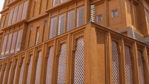 A multi-story building with a traditional architectural style, featuring a series of balconies and decorative lattice windows. - Devraha Seva Ashram - Vrindavan (Mathura)