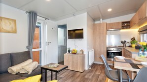 Ein moderner, kompakter Wohnraum mit Sofa, Esstisch und Küchenzeile.