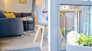 Ein modernes Wohnzimmer mit einem grauen Sofa, einem blauen Sessel und einem kleinen Tisch.