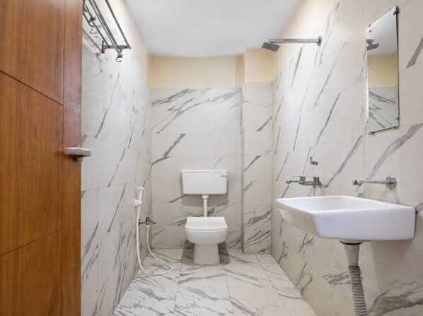Un baño con inodoro, lavamanos y ducha.
