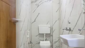 Un baño pequeño con inodoro, lavamanos y ducha.