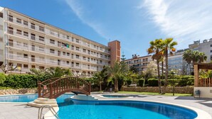 A hotel with a swimming pool, a bridge, and a multi-story building with balconies. - Apartment Arquus by Interhome (Salou)