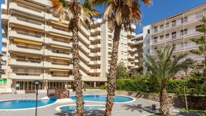A hotel with multiple balconies, a swimming pool, and palm trees. - Apartment Arquus by Interhome (Salou)