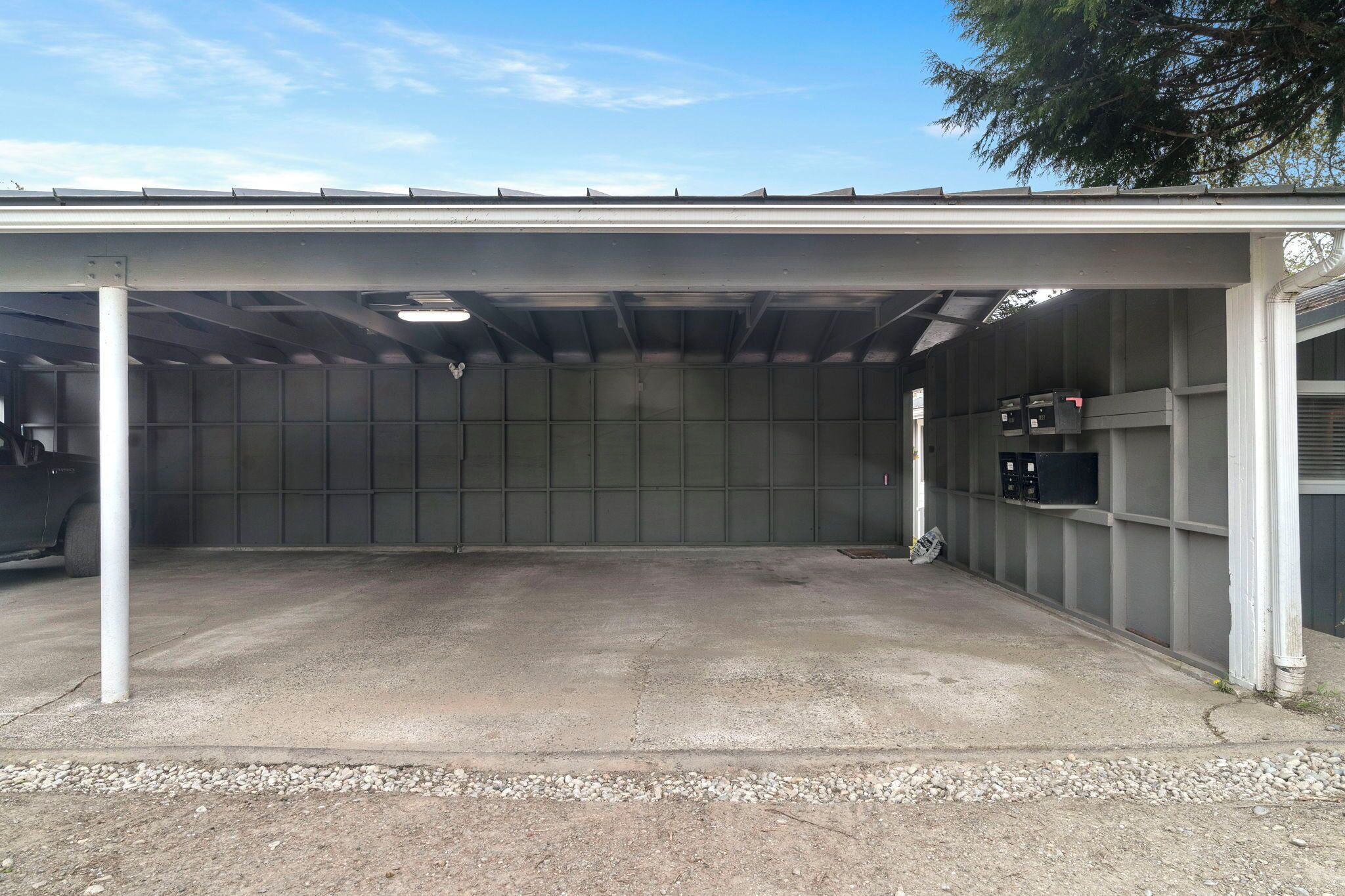 Ein überdachter Parkbereich mit Betonboden und Metallwänden.