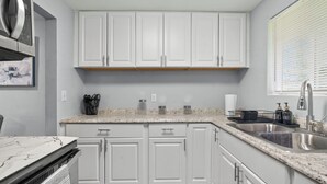 Eine moderne Küche mit weißen Schränken, Granit-Arbeitsplatten und Edelstahlgeräten.