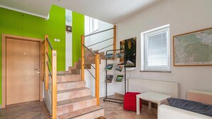 A staircase with a wooden handrail, a red cushion, a white table, and a map on the wall. - Lavrič Studio 1 at Lake Bloke, Bloke, Slovenia (Bloke)