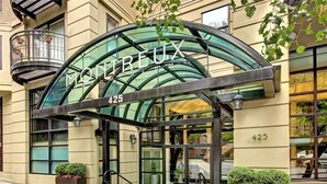 Une entrée moderne avec une façade en verre et le nom « MONTRUEUX » affiché en caractères bien visibles.